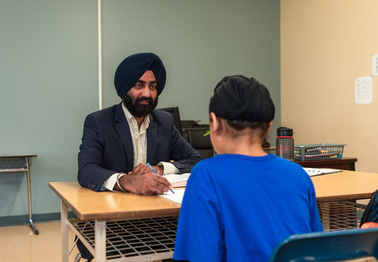 Two people in a one-to-one coaching conversation at a table